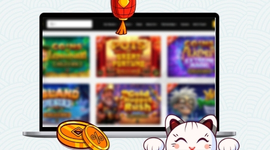 A lucky cat and gold coins in front of a laptop showing various casino games.